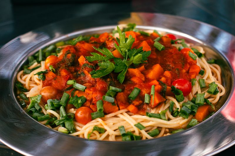 Homemade tomato pizza sauce being prepared with fresh herbs